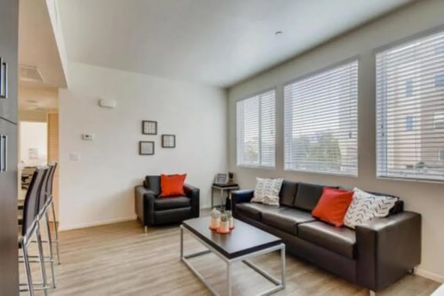 Black leather sofa and chair living room living room at Prisma in San Diego Student Accommodation