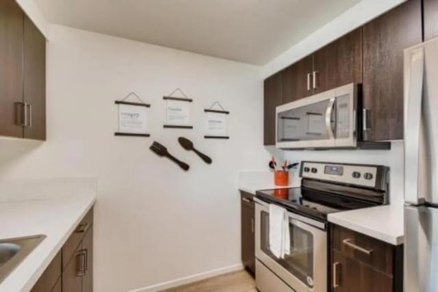 Dark cabinets microwave stove and framed art kitchen at Prisma in San Diego Student Accommodation
