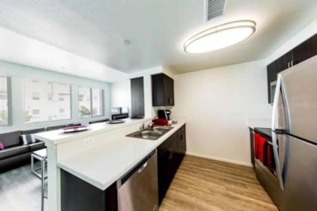 Kitchen with island dark cabinets stainless steel appliances living room kitchen at Prisma in San Diego Student Accommodation