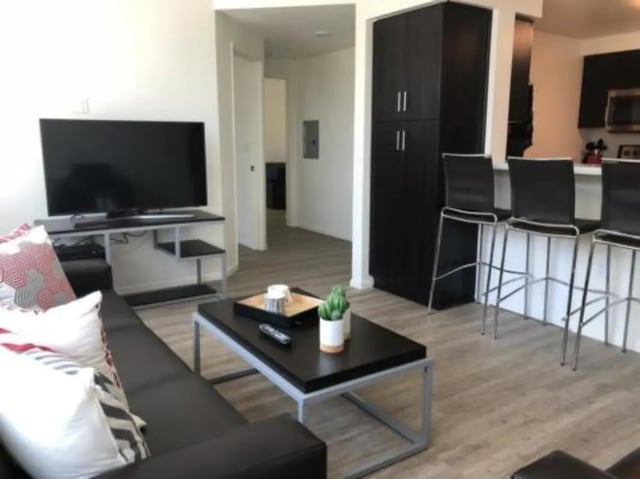 Sofa TV coffee table bar stools living room at Prisma in San Diego Student Accommodation