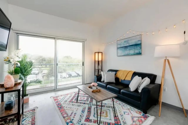 Black couch patterned rug wood coffee table living room at The Loop in Isla Vista Student Accommodation