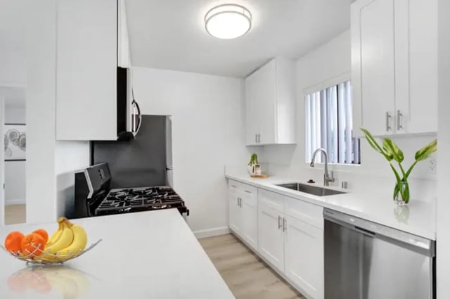 White cabinets gas stove stainless steel refrigerator kitchen at Valleywood in Los Angeles Student Accommodation