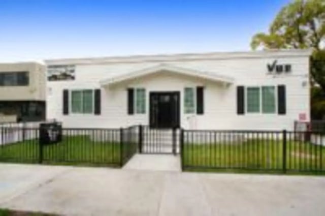 White building with black shutters and fence exterior at Heritage 2831 in Los Angeles Student Accommodation
