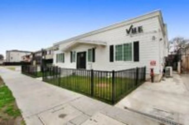 White building black fenced lawn exterior at Heritage 2831 in Los Angeles Student Accommodation