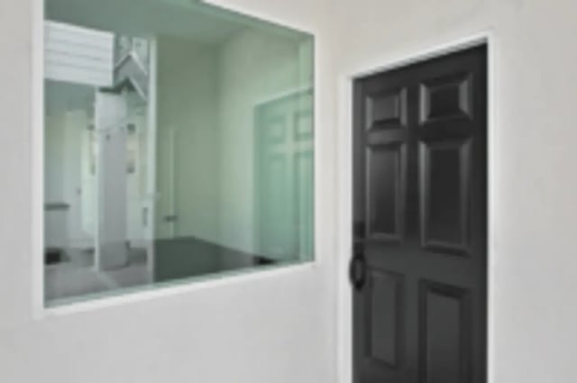 Glass window reflection and black door hallway at Heritage 2831 in Los Angeles Student Accommodation