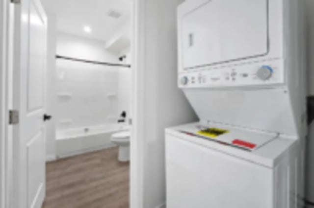 Stacked washer dryer next to bathroom tub and toilet. at Heritage 2831 in Los Angeles Student Accommodation