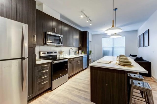 Modern kitchen with stainless steel appliances island and stools kitchen at The Helmsman in Savannah Student Accommodation