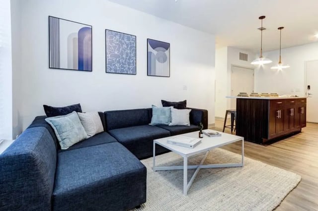Dark blue sectional sofa white coffee table living room at The Helmsman in Savannah Student Accommodation