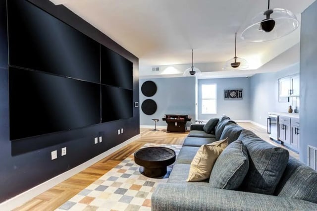 Wall of TVs sectional couch and bar living room at The Helmsman in Savannah Student Accommodation