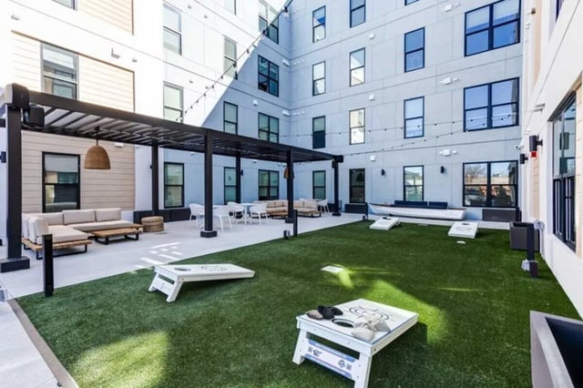 Outdoor seating cornhole boards and grass courtyard exterior at The Helmsman in Savannah Student Accommodation