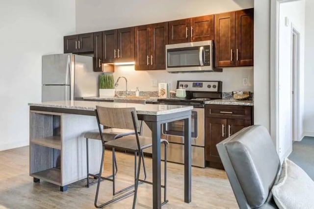 Modern kitchen with island two chairs and refrigerator kitchen at Everly On The Loop in St. Louis Student Accommodation