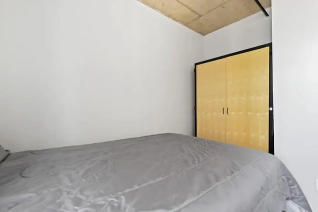 Bed with gray comforter and wood closet bedroom at Auraria Student Lofts in Denver Student Accommodation