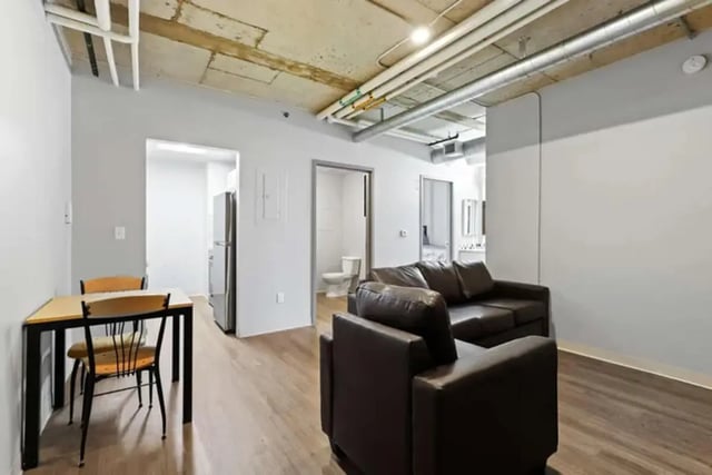 Dining table sofa and doorway to bathroom Living room at Auraria Student Lofts in Denver Student Accommodation