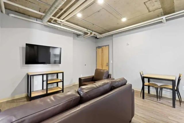 Leather sofa tv table chairs and table living room at Auraria Student Lofts in Denver Student Accommodation
