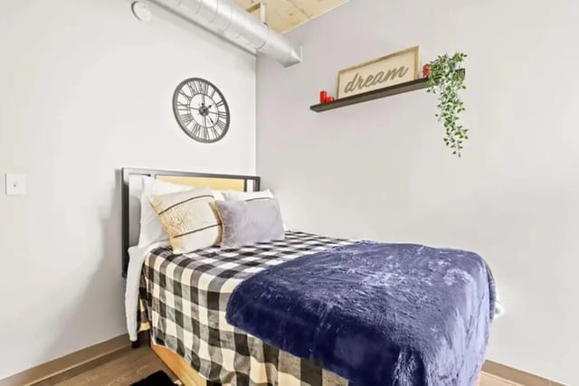 Bed with buffalo check and blue blankets bedroom at Auraria Student Lofts in Denver Student Accommodation