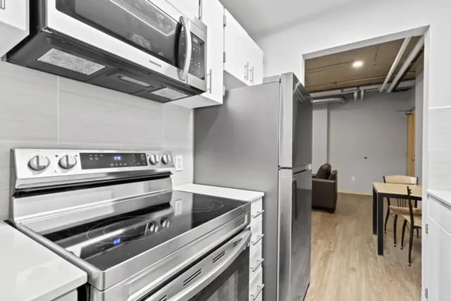 Stainless steel stove microwave refrigerator and table kitchen at Auraria Student Lofts in Denver Student Accommodation