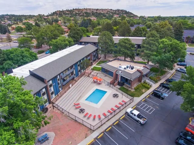 Apartment buildings with swimming pool and parking lot exterior at Aviator Apartments in Colorado Springs Student Accommodation