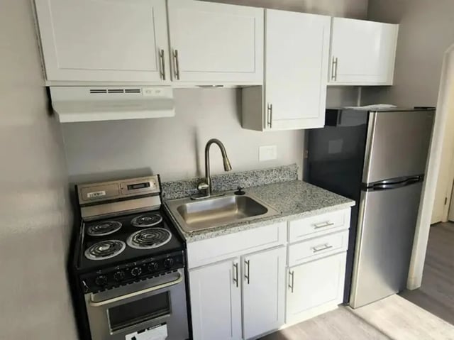White cabinets stove sink refrigerator kitchen area at Chestnut Springs Apartments in Colorado Springs Student Accommodation