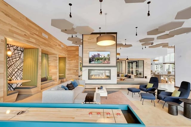 Shuffleboard table fireplace couches seating area living room at Claro at High Point in Aurora Student Accommodation