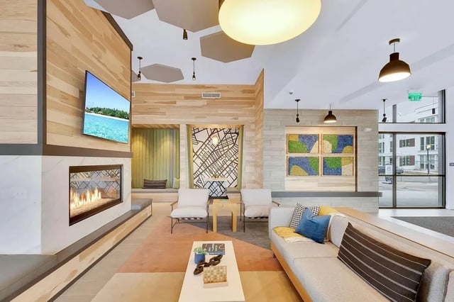 Sofa fireplace TV artwork modern common area living room at Claro at High Point in Aurora Student Accommodation