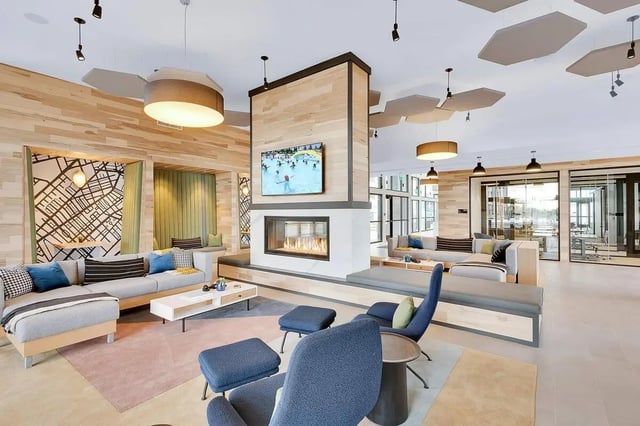 Modern lounge with fireplace, sectional sofa, chairs, living room at Claro at High Point in Aurora Student Accommodation