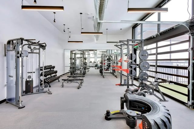 Gym equipment weight racks and benches Fitness area at Claro at High Point in Aurora Student Accommodation