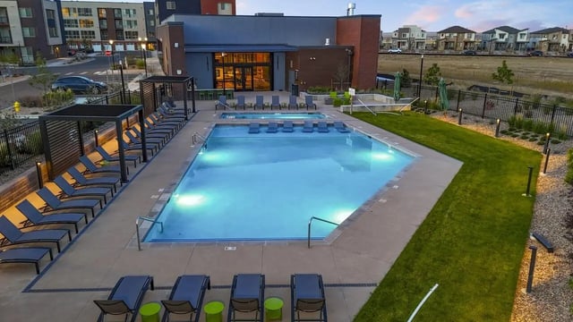 Pool with lounge chairs and jacuzzi area at Claro at High Point in Aurora Student Accommodation