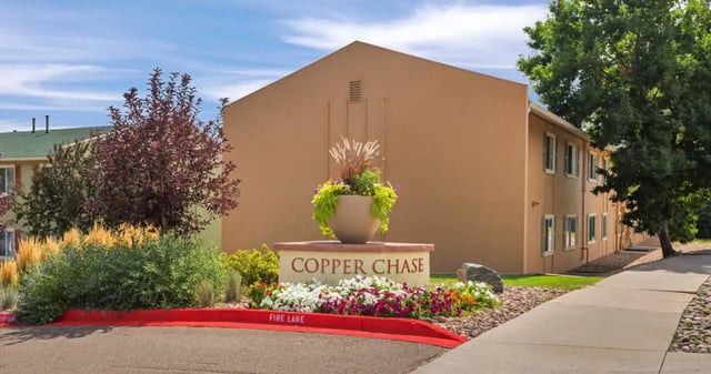 Copper Chase sign with flowers exterior at Copper Chase Apartments in Colorado Springs Student Accommodation