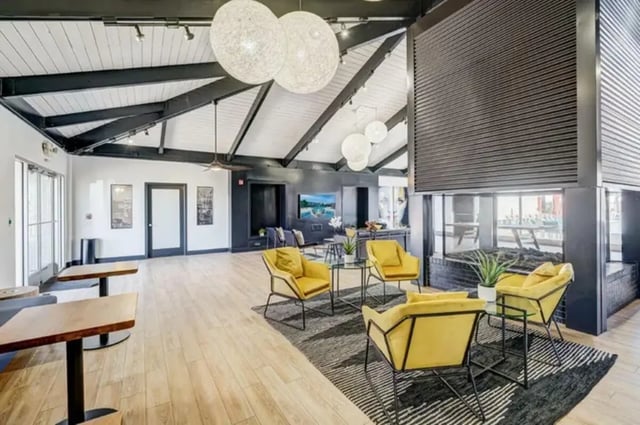 Yellow chairs glass tables fireplace communal area living room at Copper Chase Apartments in Colorado Springs Student Accommodation