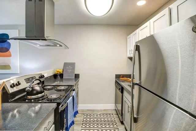 Stove refrigerator dishwasher cabinets rug kitchen at Copper Chase Apartments in Colorado Springs Student Accommodation