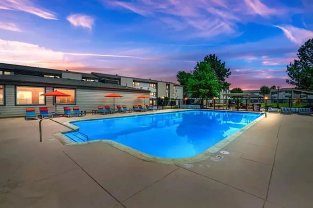 Blue pool lounge chairs umbrellas outdoor living area at Flight at Lowry in Aurora Student Accommodation