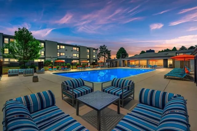 Pool lounge chairs umbrellas seating area exterior at Flight at Lowry in Aurora Student Accommodation