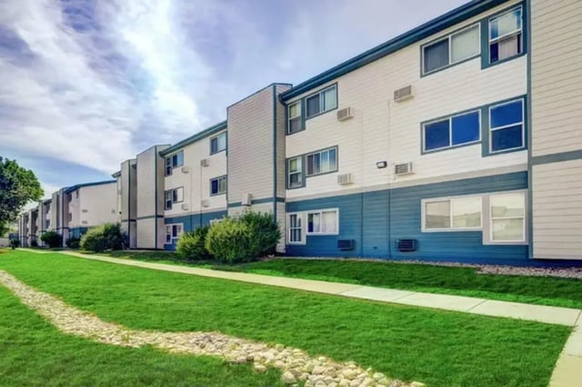 Apartment building white blue siding grass exterior at Flight at Lowry in Aurora Student Accommodation