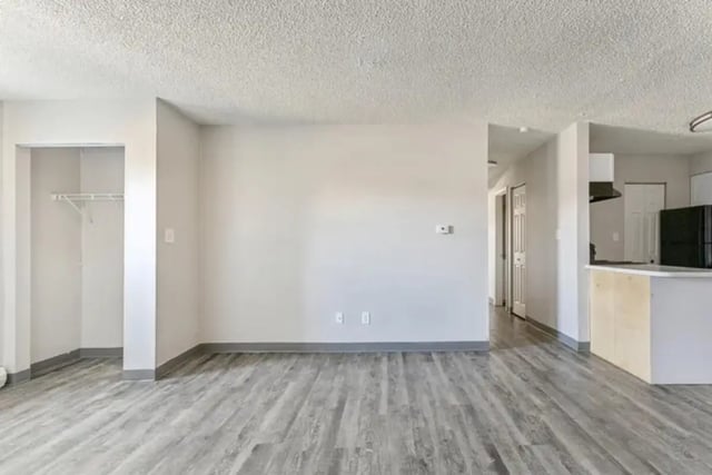 Empty room with closet and kitchen area Living room at Lincoln Springs Apartments in Colorado Springs Student Accommodation