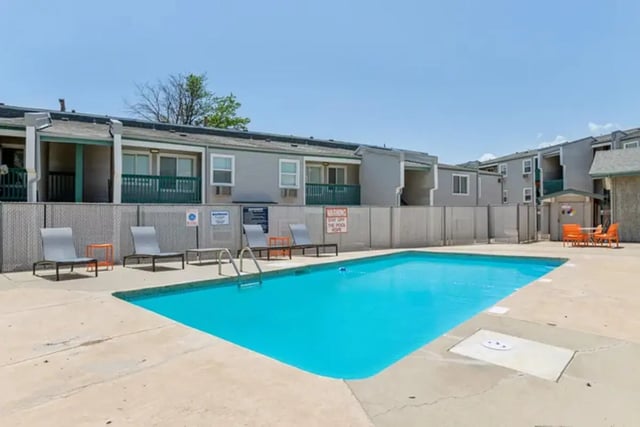 Pool with lounge chairs and apartments exterior at Lincoln Springs Apartments in Colorado Springs Student Accommodation