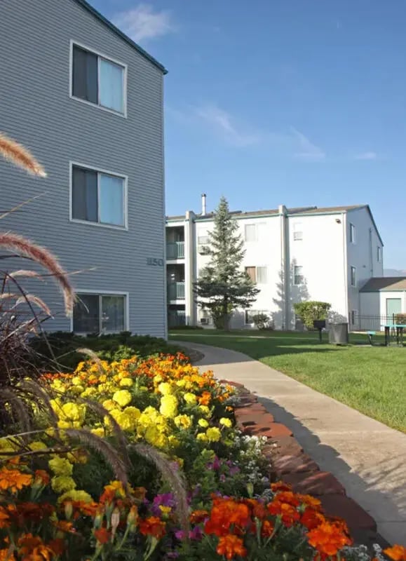 Colorful flower bed sidewalk building exterior at Lincoln Springs Apartments in Colorado Springs Student Accommodation