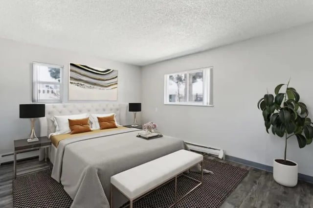 Bed with white headboard orange pillows artwork bedroom at Lincoln Springs Apartments in Colorado Springs Student Accommodation