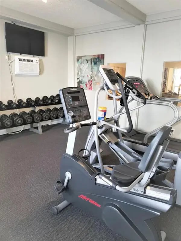 Dumbbells exercise bikes treadmill TV gym at Lincoln Springs Apartments in Colorado Springs Student Accommodation