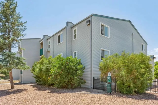 Two-story building with trees and bushes exterior at Lincoln Springs Apartments in Colorado Springs Student Accommodation