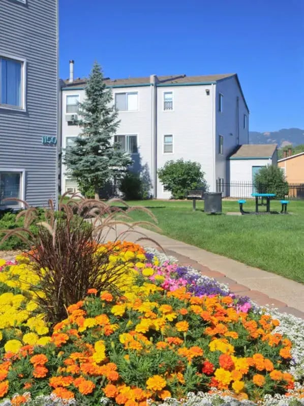 Colorful flower bed next to apartment buildings exterior at Lincoln Springs Apartments in Colorado Springs Student Accommodation