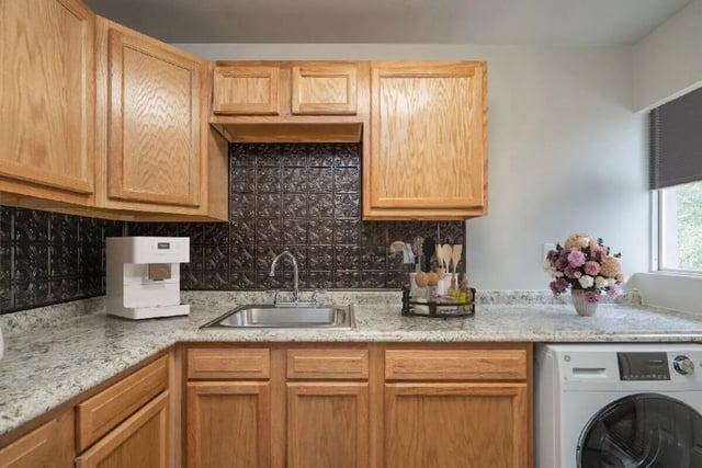 Kitchen with coffee maker sink cabinets and washer kitchen at Newport Square Apartments in Colorado Springs Student Accommodation