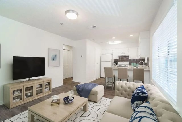 Sofa tv coffee table kitchen bar living room at Newport Square Apartments in Colorado Springs Student Accommodation
