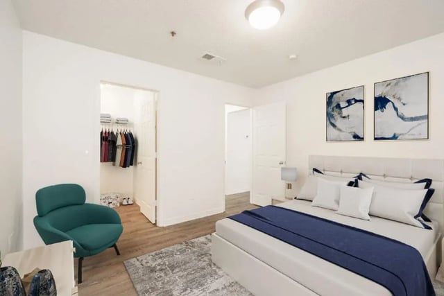 Bed with blue accents teal chair closet bedroom at Newport Square Apartments in Colorado Springs Student Accommodation