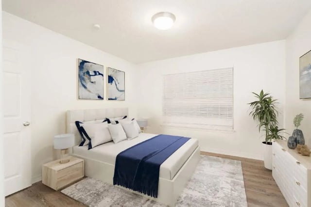Bed pillows navy throw rug artwork bedroom at Newport Square Apartments in Colorado Springs Student Accommodation