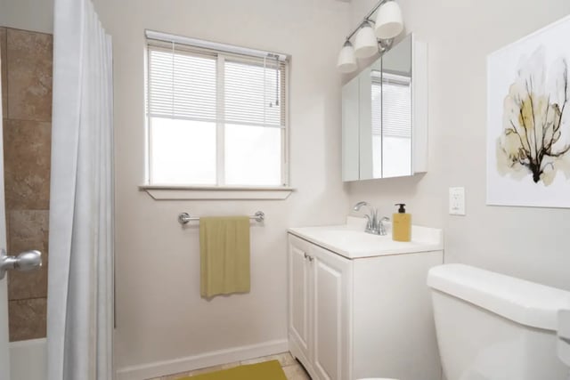 Sink toilet vanity shower curtain window artwork bathroom at Newport Square Apartments in Colorado Springs Student Accommodation