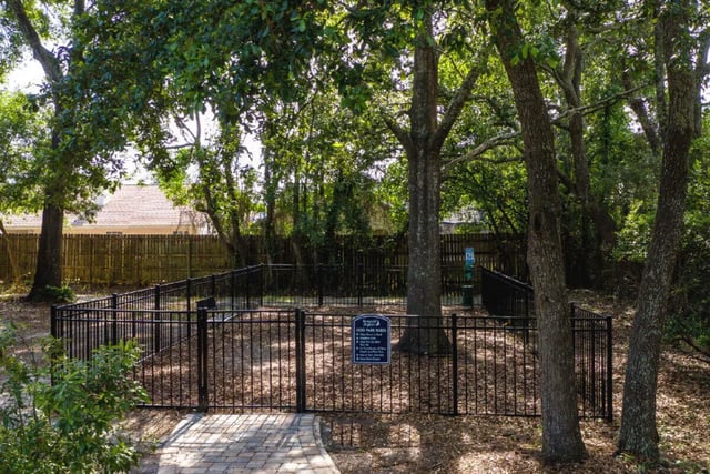 Fenced dog park with benches and rules sign outdoor area at Newport Square Apartments in Colorado Springs Student Accommodation