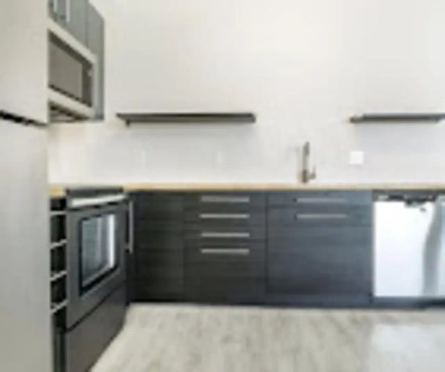 Modern kitchen with dark cabinets stainless steel appliances kitchen at Red Table Apartments in Gypsum Student Accommodation