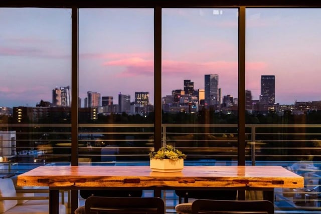 Wooden table with potted plant cityscape view living room at RYE SoBo in Denver Student Accommodation