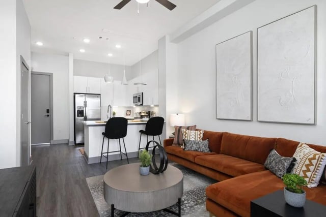 Orange sectional sofa kitchen island bar stools living room at RYE SoBo in Denver Student Accommodation