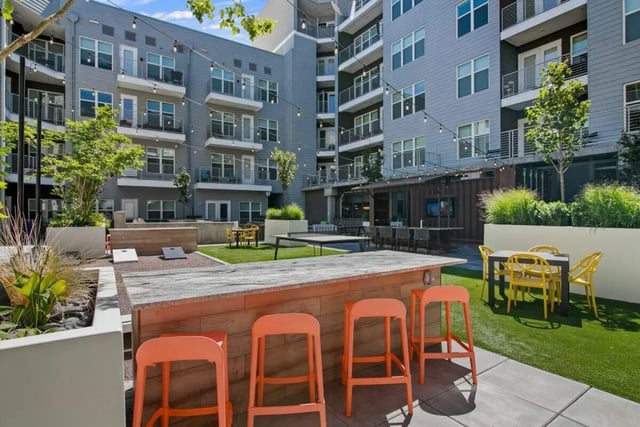 Outdoor bar with orange stools and patio tables exterior at RYE SoBo in Denver Student Accommodation